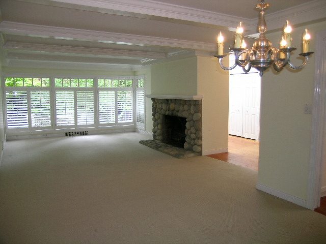 Spacious living room with stone fireplace, hardwood floors, and large windows. - 2795 Palmerston Avenue, West Vancouver