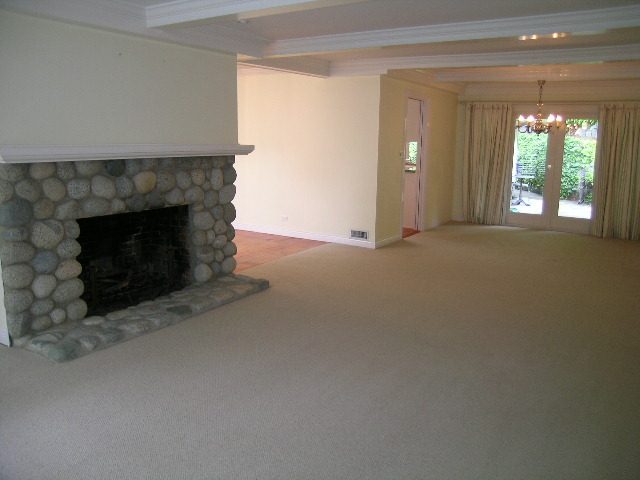 Spacious living room with stone fireplace and large windows, perfect for relaxation. - 2795 Palmerston Avenue, West Vancouver