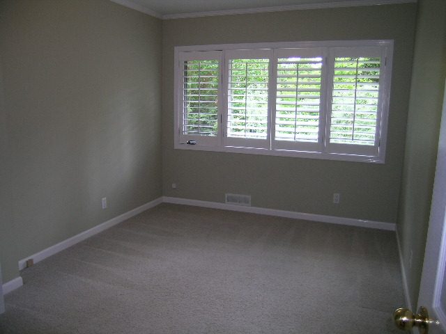 Spacious bedroom with large windows, white shutters, and built-in bench seating. - 2795 Palmerston Avenue, West Vancouver