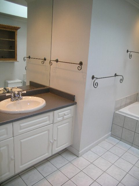 Spacious bathroom with dark countertops, white cabinets, and tiled flooring. - 2795 Palmerston Avenue, West Vancouver