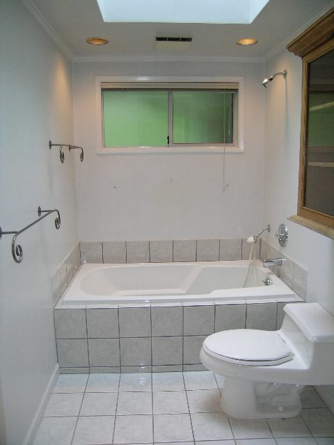 Bathroom with tiled walls, modern tub, and frosted window. - 2795 Palmerston Avenue, West Vancouver
