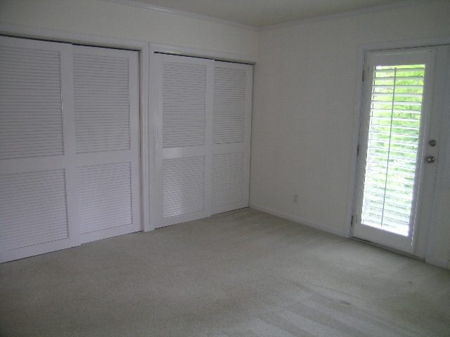Spacious bedroom with white closet doors and carpeted floor. - 2795 Palmerston Avenue, West Vancouver