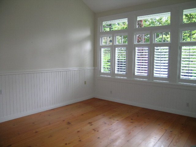 Spacious sunroom with hardwood floors and large windows offering a view of greenery. - 2795 Palmerston Avenue, West Vancouver