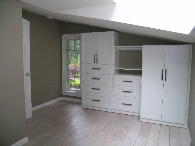Spacious bedroom with built-in white cabinets, hardwood floors, and a window view. - 2795 Palmerston Avenue, West Vancouver