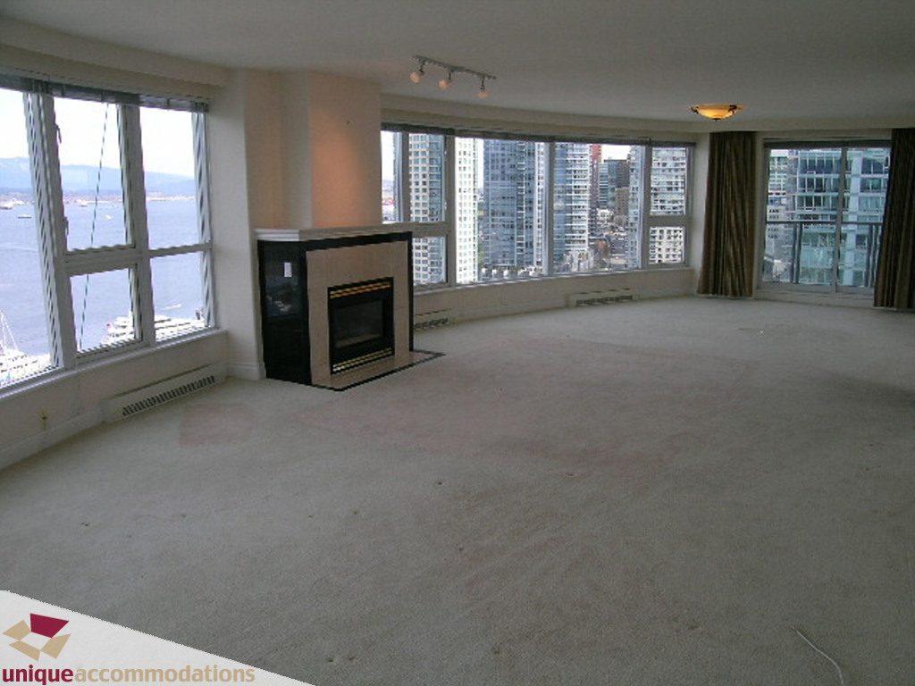 Spacious living room with large windows offering a stunning city view and modern fireplace. - 1903 - 535 Nicola Street, Vancouver Downtown