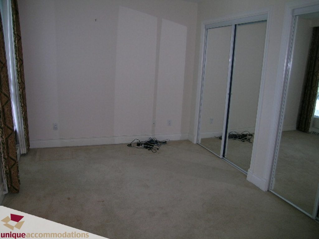 Spacious bedroom with mirrored closet doors and beige carpet. - 1903 - 535 Nicola Street, Vancouver Downtown