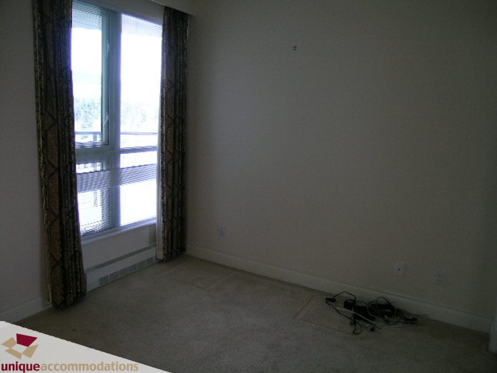 Spacious living room with large windows and a view, carpeted floor, and minimal decor. - 1903 - 535 Nicola Street, Vancouver Downtown