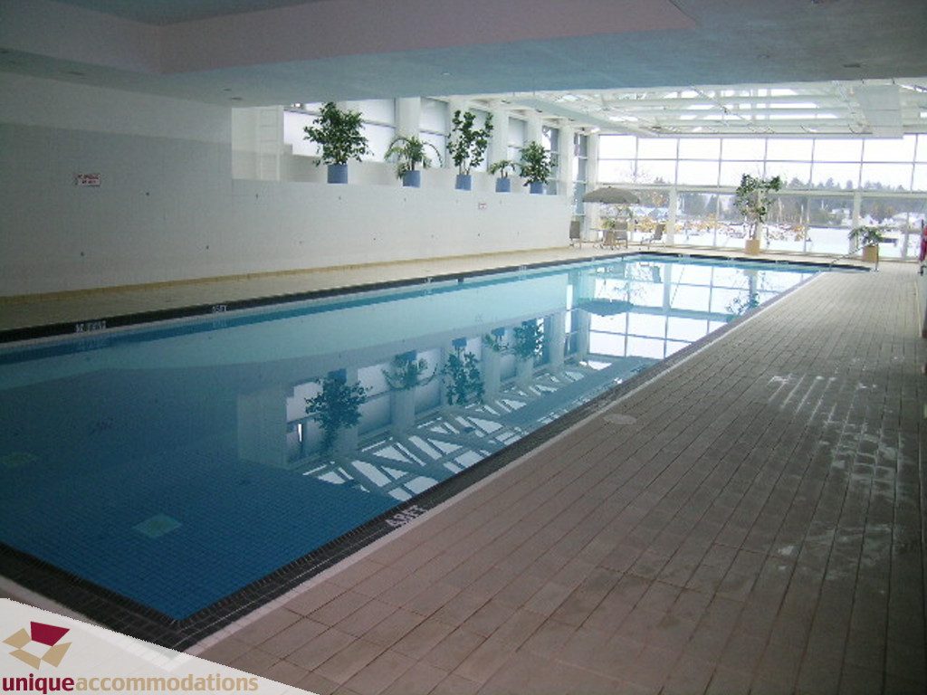 Spacious indoor pool with large windows and plants, perfect for relaxation. - 1903 - 535 Nicola Street, Vancouver Downtown