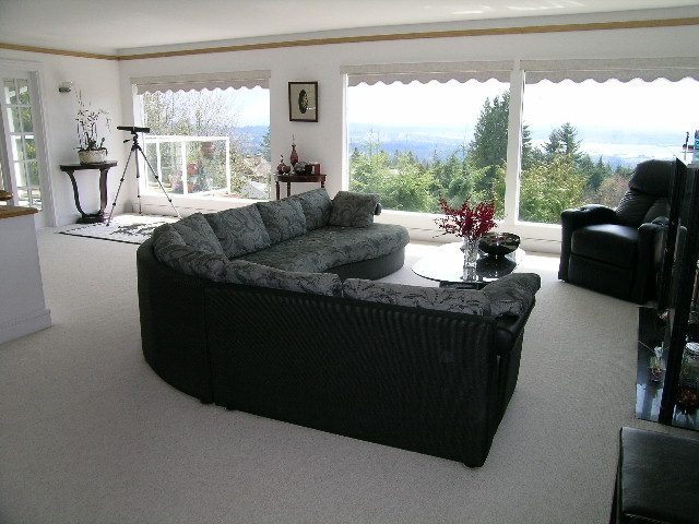 Spacious living room with large windows, city view, and comfortable furniture. - 1104 Hillside Road, West Vancouver