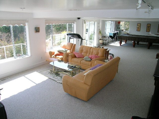 Spacious living room with large windows, pool table, and comfortable furniture. - 1104 Hillside Road, West Vancouver