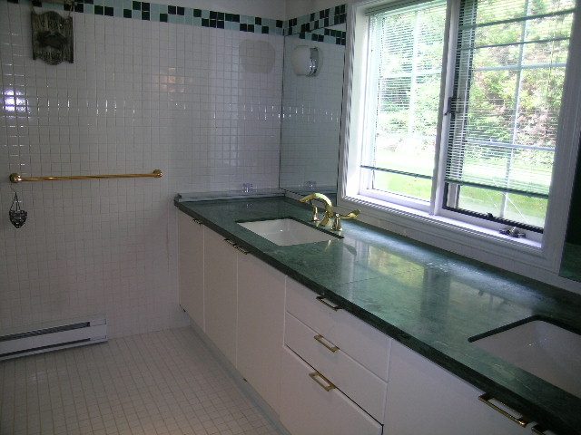 Bright bathroom with white tile walls, green countertops, and a window view. - 1104 Hillside Road, West Vancouver