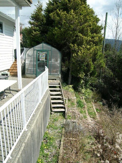 Furnished patio with white railing and steps leading to a small greenhouse. - 1104 Hillside Road, West Vancouver