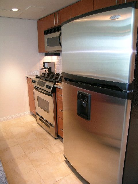 Bright kitchen with stainless steel appliances, granite countertops, and tiled flooring. - TH1 - 188 East Esplanade, North Vancouver