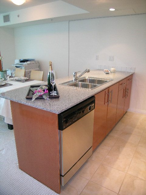 Bright kitchen with granite countertops, stainless steel sink, and wooden cabinets. - TH1 - 188 East Esplanade, North Vancouver