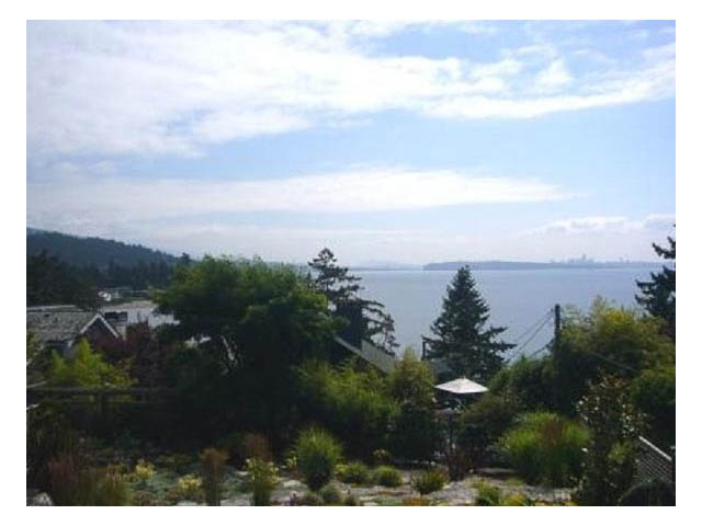Spacious living room with a stunning city view and lush greenery. - 4750 The Highway, West Vancouver