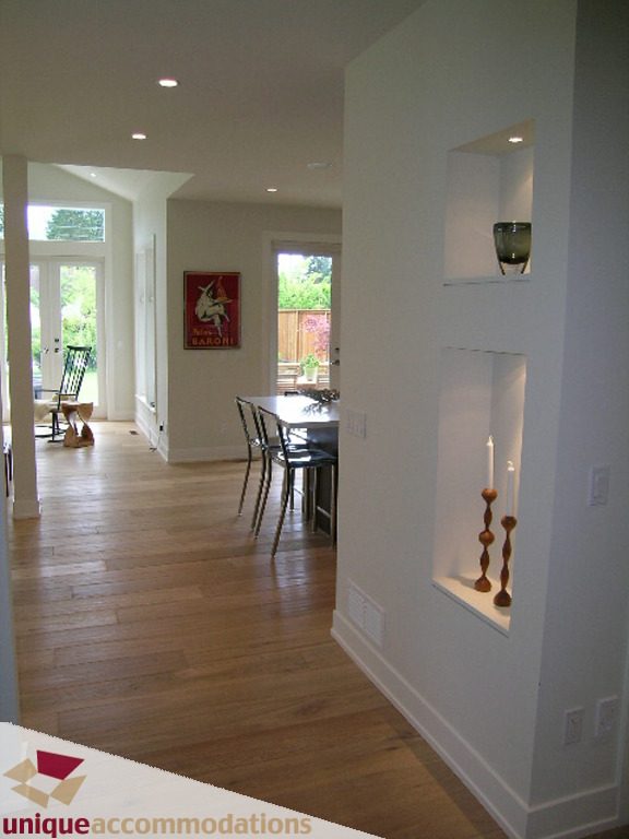 Spacious dining area with hardwood floors, modern shelving, and a view of the backyard. - 2015 Lloyd Avenue, North Vancouver