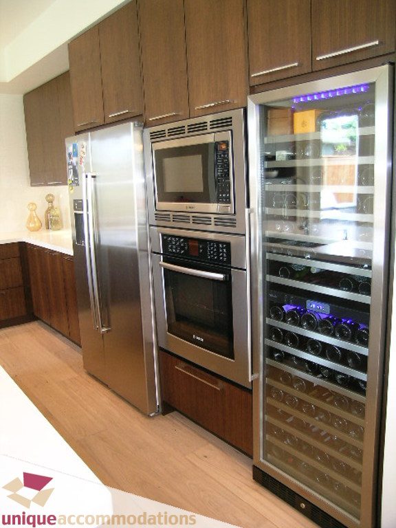 Bright kitchen with stainless steel appliances, hardwood floors, and a wine cooler. - 2015 Lloyd Avenue, North Vancouver