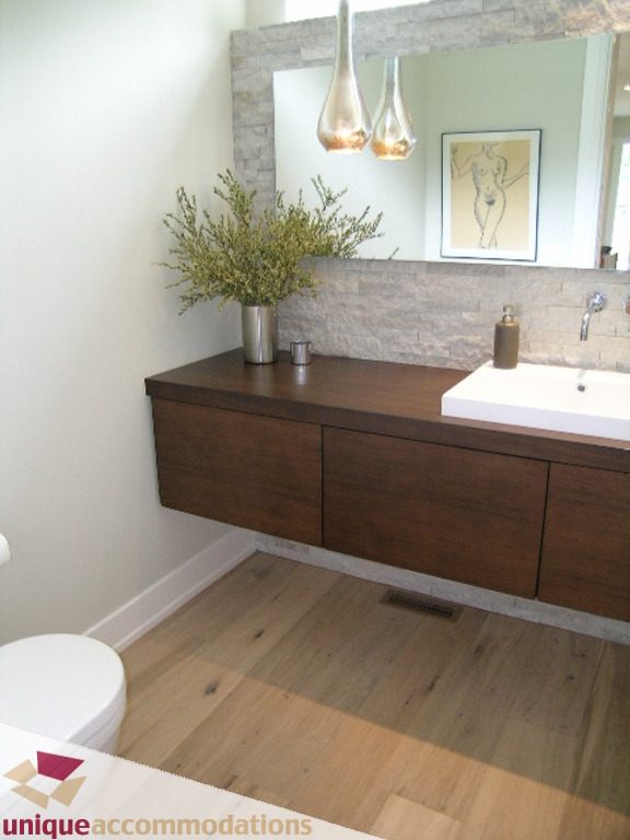 Modern bathroom with dark wood floating vanity, white sink, and hardwood floors. - 2015 Lloyd Avenue, North Vancouver