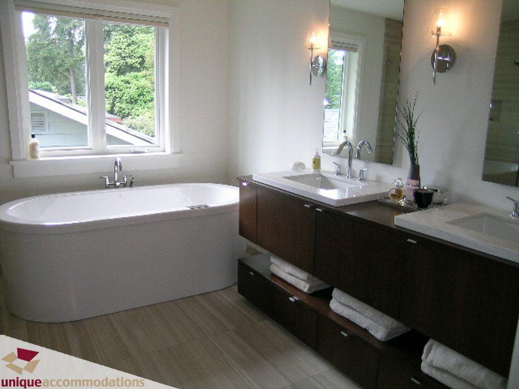 Spacious bathroom with modern fixtures, hardwood floors, and a city view. - 2015 Lloyd Avenue, North Vancouver