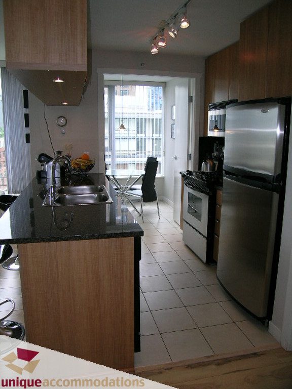 Bright kitchen with granite countertops, stainless steel appliances, and hardwood floors. - 707 - 1010 Richards Street, Vancouver Downtown