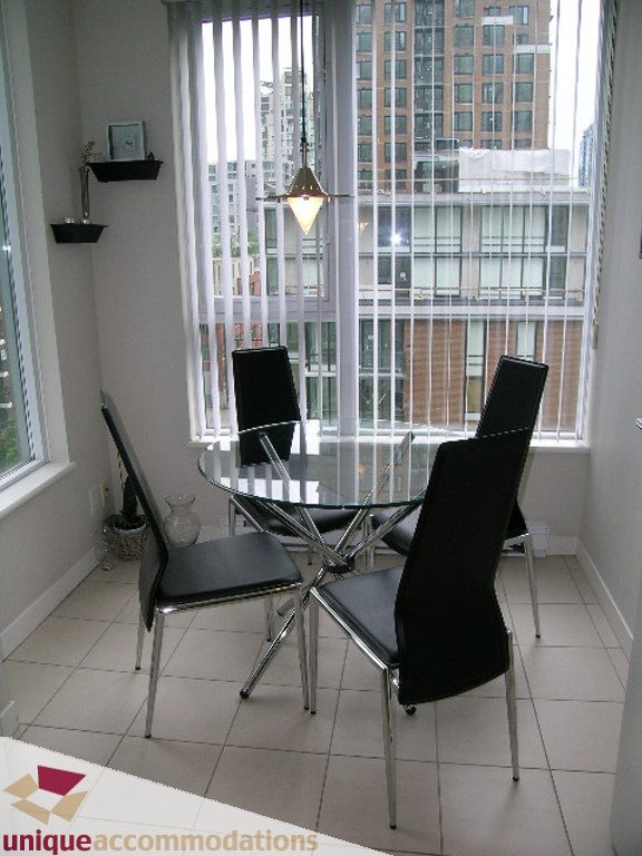 Bright dining area with glass table, black chairs, and city view. - 707 - 1010 Richards Street, Vancouver Downtown