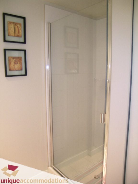 Bathroom with glass shower and framed artwork on wall. - 707 - 1010 Richards Street, Vancouver Downtown