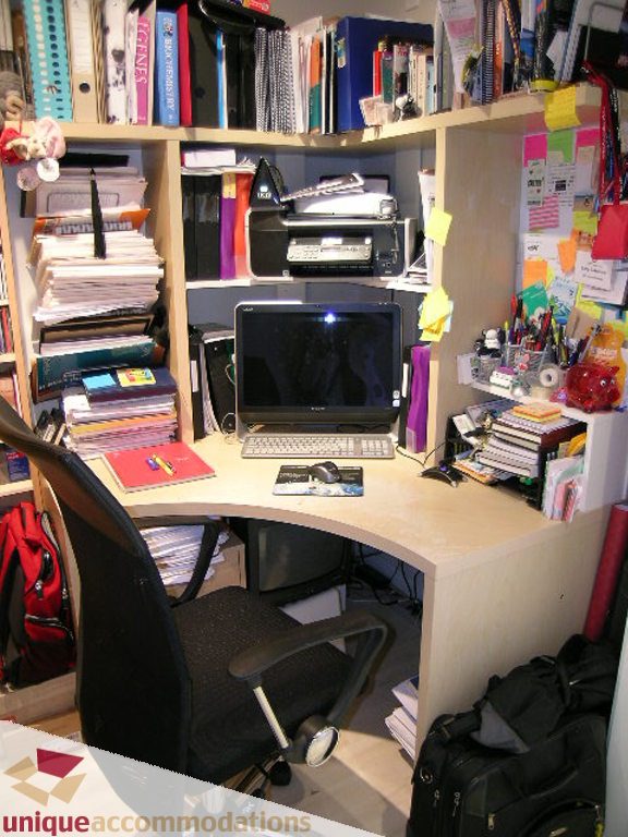 Furnished corner desk with computer and cluttered shelves, suggesting a workspace. - 707 - 1010 Richards Street, Vancouver Downtown
