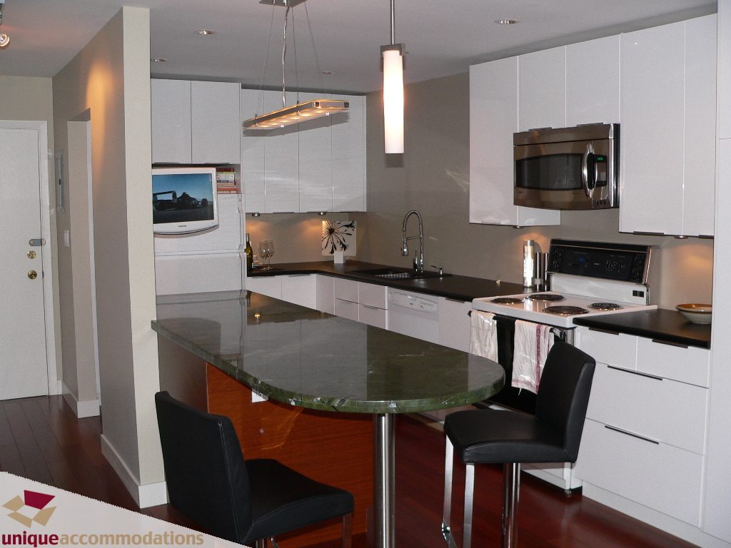 Bright kitchen with modern white cabinets, granite countertops, and hardwood floors. - 203 - 1066 W 13th Ave, Vancouver West Side