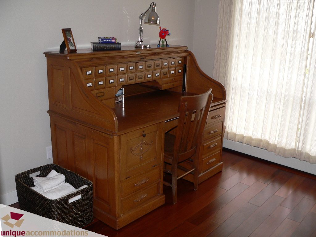 Bright bedroom with wooden desk, hardwood floors, and a wicker basket. - 203 - 1066 W 13th Ave, Vancouver West Side