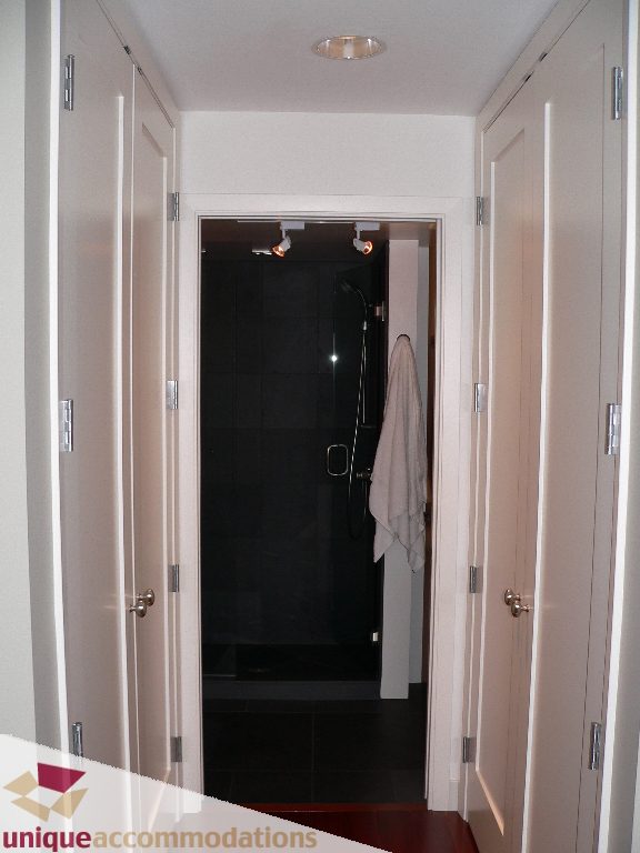 Furnished bathroom with dark tiles and a towel hanging. - 203 - 1066 W 13th Ave, Vancouver West Side