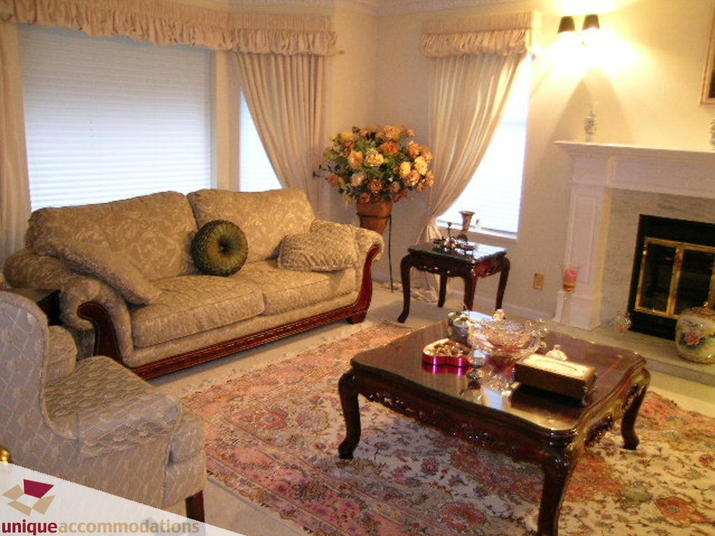 Furnished living room with ornate furniture, floral rug, and fireplace. - 5735 Nancy Green way, North Vancouver