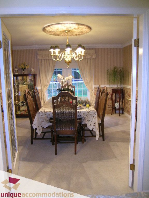 Formal dining room with elegant chandelier, striped wallpaper, and large windows. - 5735 Nancy Green way, North Vancouver