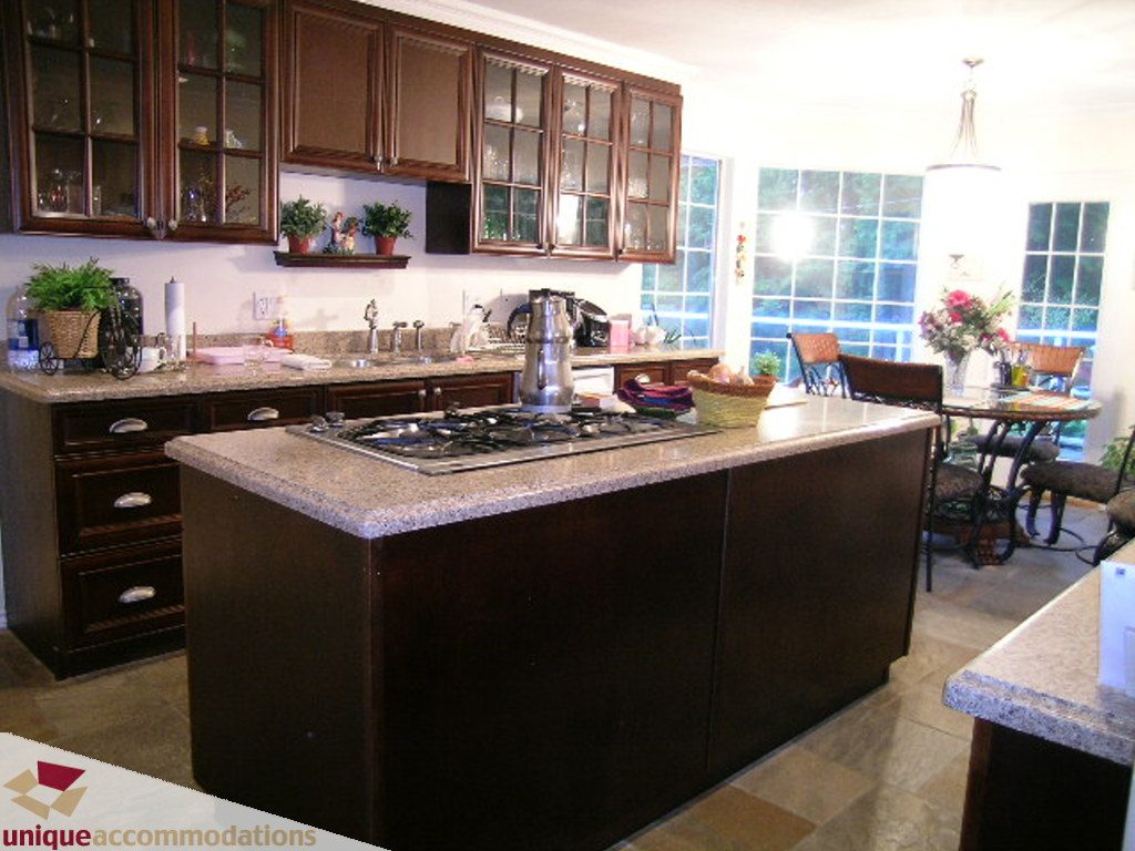 Bright kitchen with granite countertops, dark cabinets, and a large island. - 5735 Nancy Green way, North Vancouver
