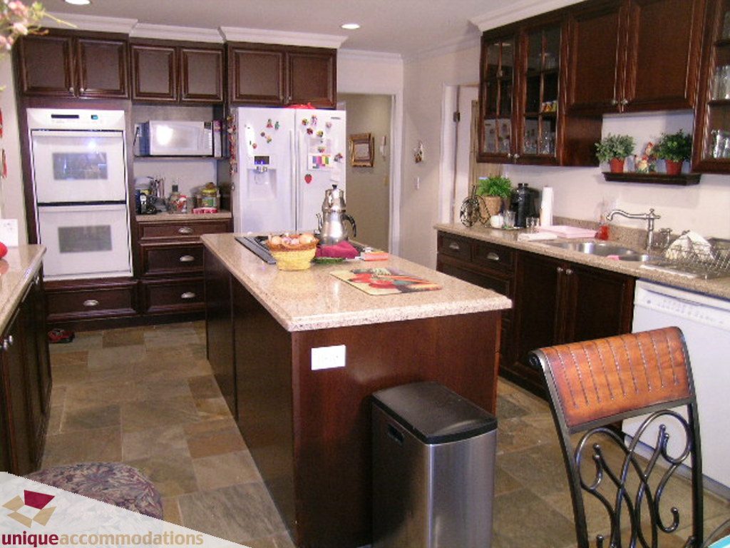 Bright kitchen with granite countertops, dark wood cabinets, and a central island, perfect for cooking and entertaining.