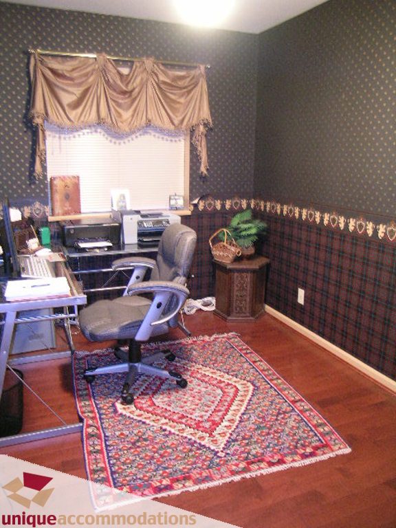 Office with hardwood floors, patterned wallpaper, and a colorful rug. - 5735 Nancy Green way, North Vancouver