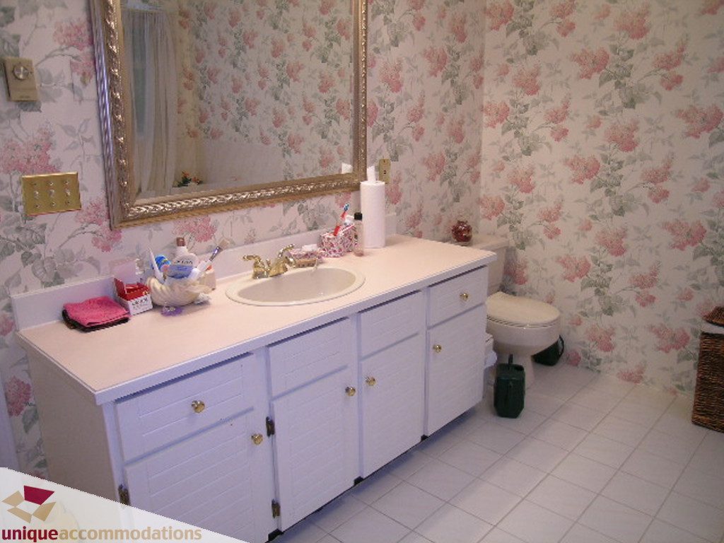 Bright bathroom with floral wallpaper and white vanity. - 5735 Nancy Green way, North Vancouver