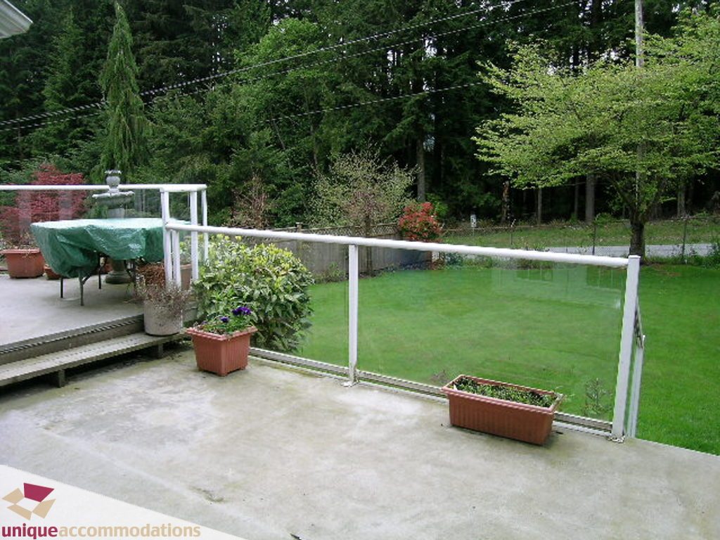 Furnished patio with potted plants and greenery, surrounded by trees. - 5735 Nancy Green way, North Vancouver