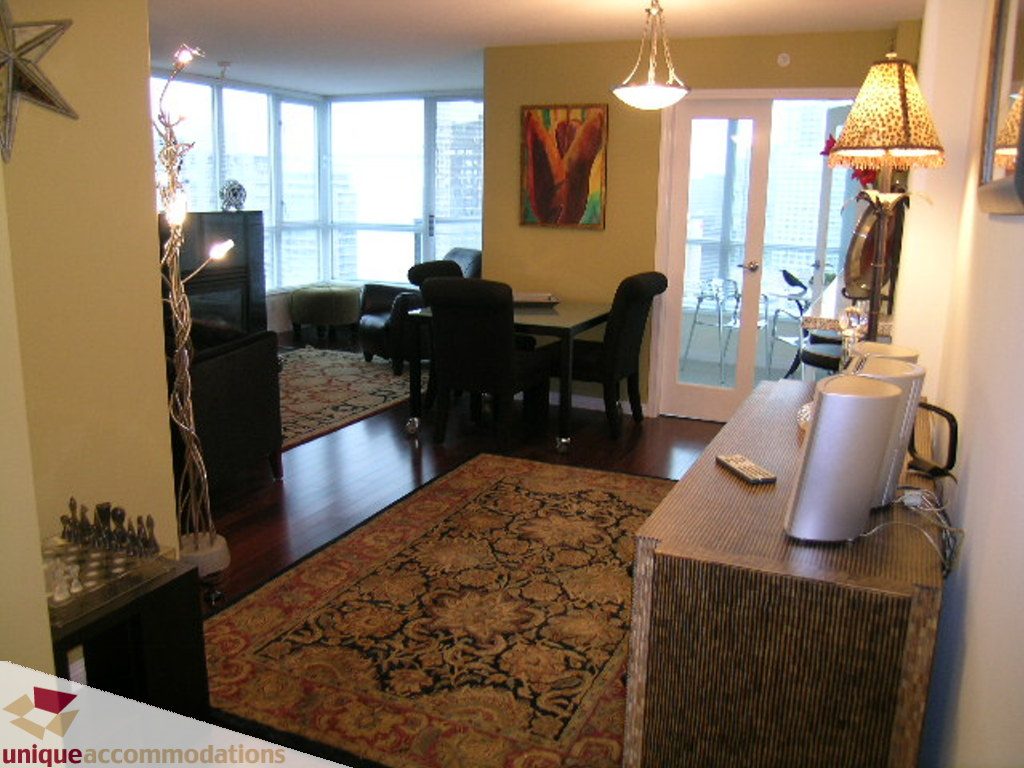 Furnished living room with hardwood floors, city view, and cozy seating area. - 2907 - 1328 W Pender St, Vancouver Downtown