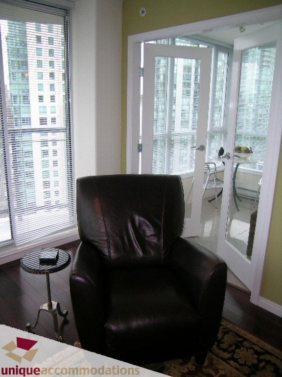 Furnished living room with leather chair, hardwood floors, and city view. - 2907 - 1328 W Pender St, Vancouver Downtown