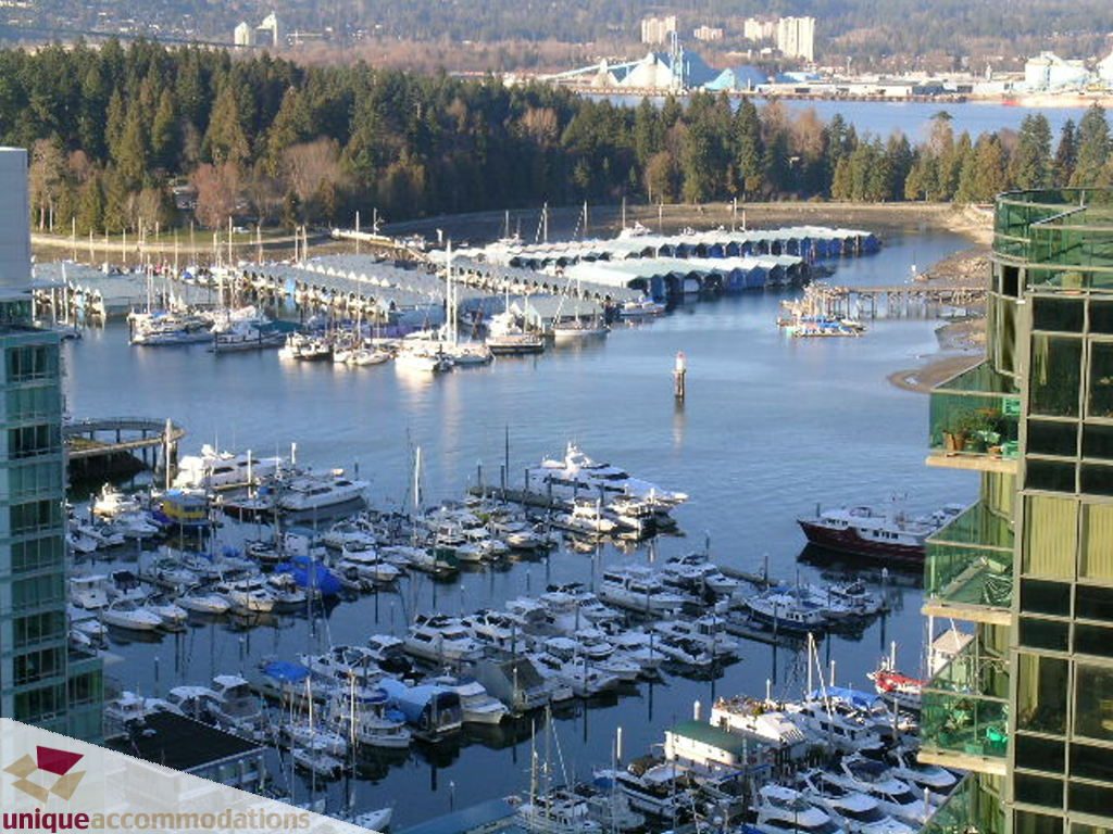 Bright living room with city view and marina, boats docked, modern furnishings. - 2907 - 1328 W Pender St, Vancouver Downtown