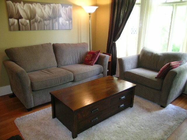 Furnished living room with a sofa, armchair, coffee table, and large window. - 3602 Fromme Rd, North Vancouver