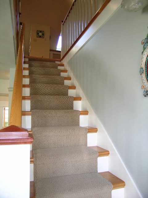 Staircase with carpeted steps and wooden railings leading to upper floor. - 3602 Fromme Rd, North Vancouver