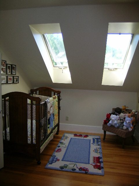 Bright bedroom with hardwood floors, skylights, and a colorful rug. - 3602 Fromme Rd, North Vancouver