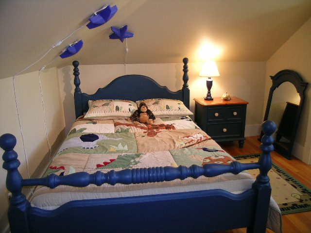 Bright bedroom with blue four-poster bed, colorful quilt, and wooden nightstand. - 3602 Fromme Rd, North Vancouver