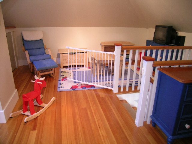 Bright living room with hardwood floors, blue furniture, and a wooden staircase. - 3602 Fromme Rd, North Vancouver