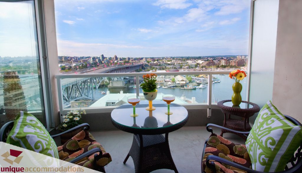 Bright balcony with city view, modern furniture, and vibrant flower arrangements. - 1806 - 1500 Howe St, Vancouver Downtown