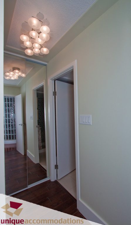 Furnished hallway with modern chandelier and hardwood floors. - 1806 - 1500 Howe St, Vancouver Downtown