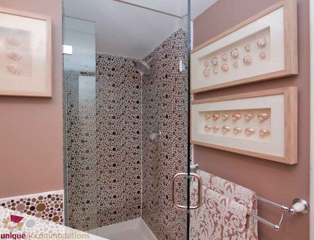 Furnished bathroom with mosaic tile shower and framed seashell art. - 1806 - 1500 Howe St, Vancouver Downtown