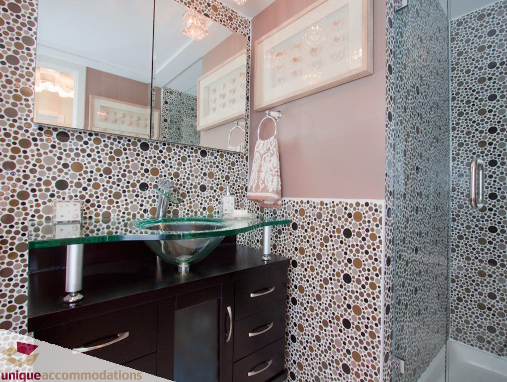 Modern bathroom with glass countertop and pebble mosaic wall. - 1806 - 1500 Howe St, Vancouver Downtown