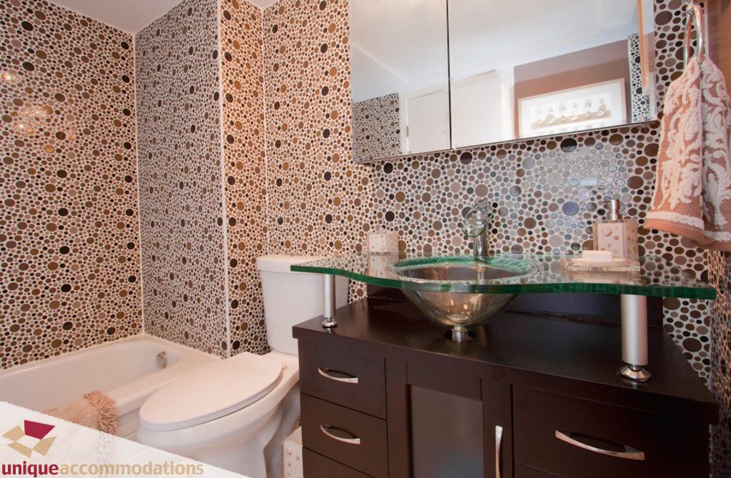 Bathroom with mosaic tile walls, glass countertops, and modern fixtures. - 1806 - 1500 Howe St, Vancouver Downtown
